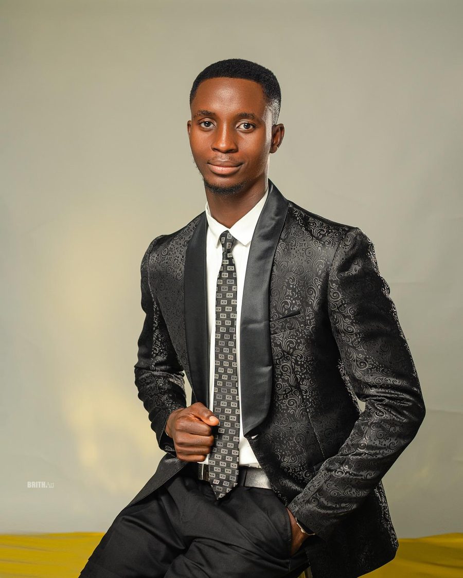 Portrait of Joshua Gboga in a black patterned suit